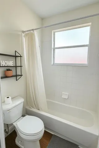 a white toilet sitting next to a bath tub shower