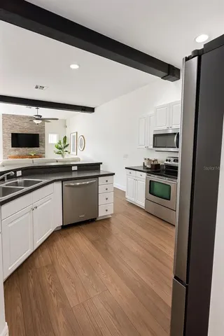 a kitchen with stainless steel appliances a stove a sink and a refrigerator