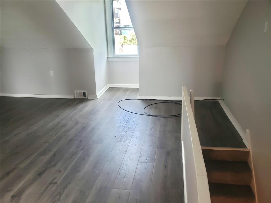 1234 Itin Street, Unit 5 Pittsburgh, PA 15212 - Photo 6 of 16 an empty room with wooden floor and windows