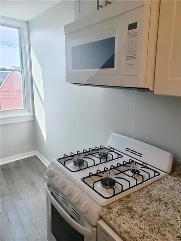 a kitchen stove sitting inside of a kitchen with white cabinets