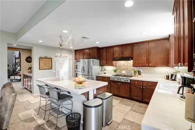 a kitchen with kitchen island a counter space stainless steel appliances and cabinets