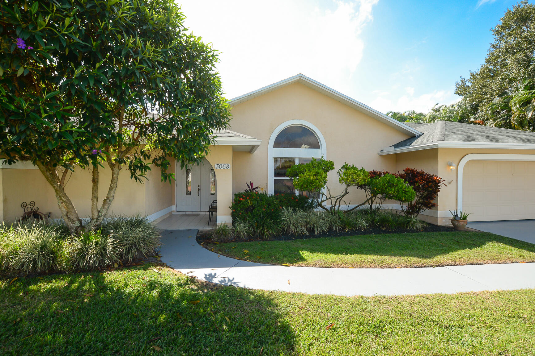 3068 Southeast Darien Road Port St. Lucie, FL 34952 - Photo 3 of 54 a front view of a house with a garden