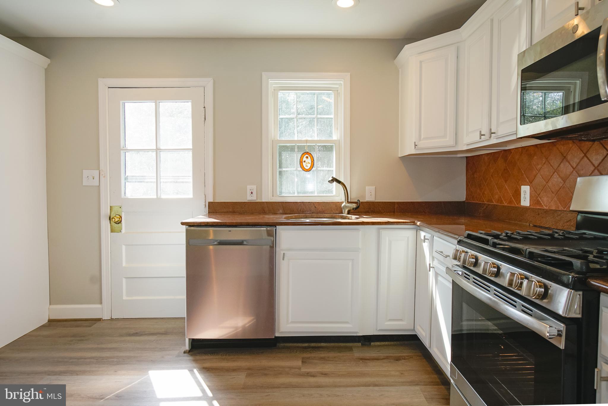 3404 Murdock Road Kensington, MD 20895 - Photo 8 of 24 a kitchen with granite countertop a stove a sink and a microwave