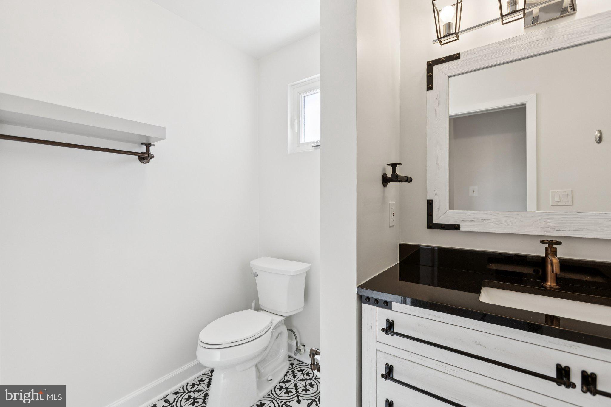 7435 8th Street Northwest Washington, DC 20012 - Photo 17 of 28 a bathroom with a sink a toilet and a mirror