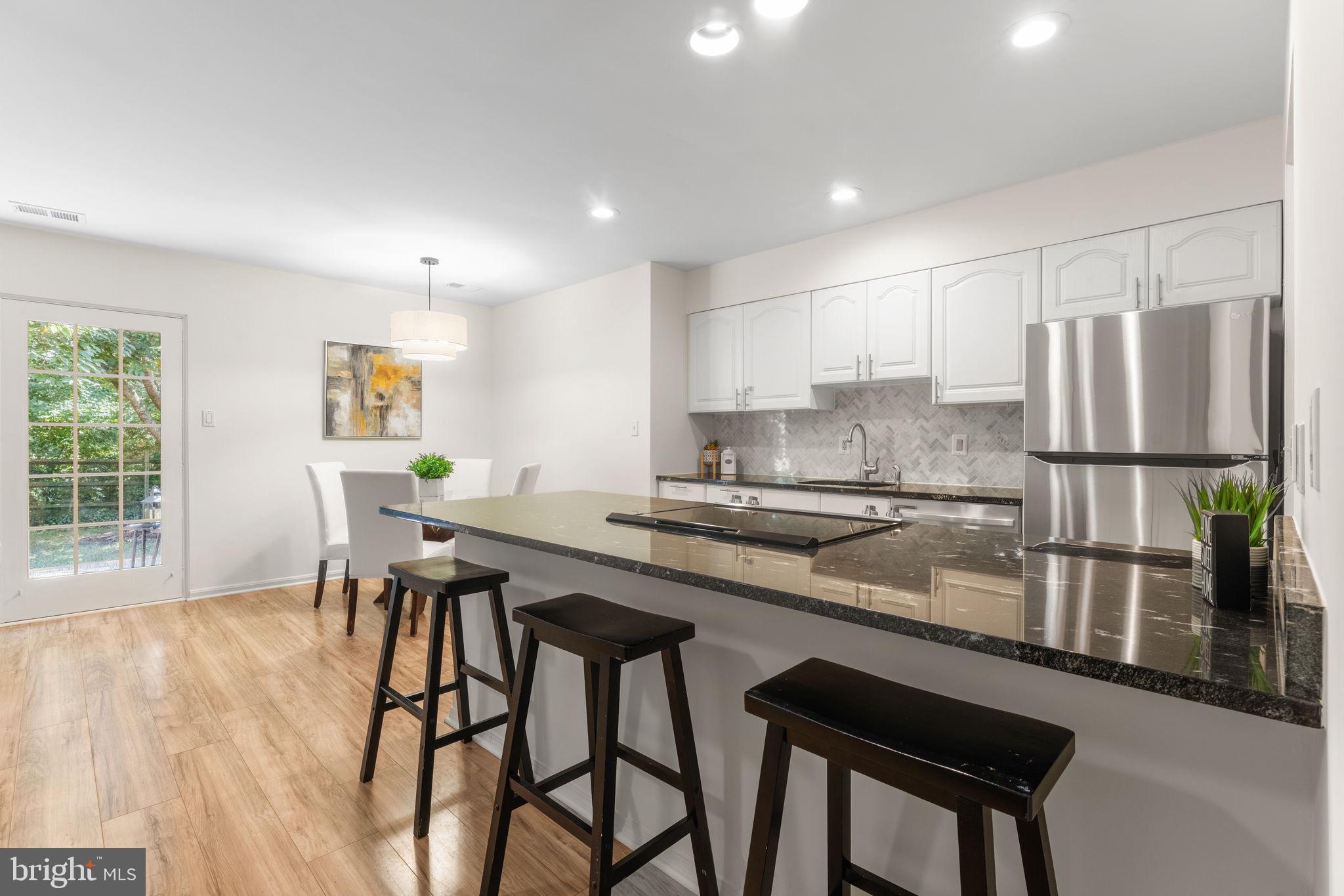 11401 Turnmill Lane Reston, VA 20191 - Photo 23 of 81 a kitchen with stainless steel appliances granite countertop table chairs sink and cabinets
