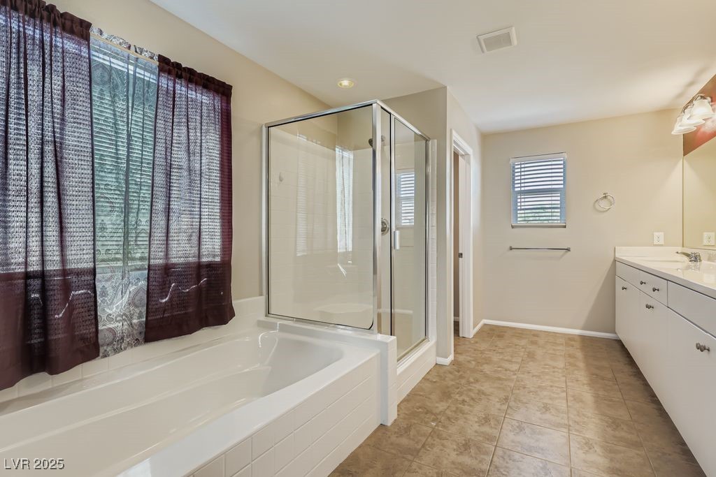 5712 Wishing Coin Court North Las Vegas, NV 89031 - Photo 11 of 24 Bathroom with vanity, a bath, a stall shower, and light tile patterned floors