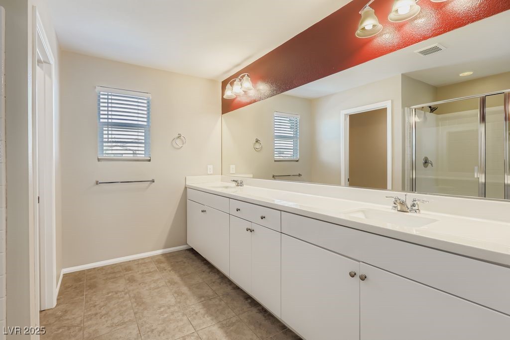 5712 Wishing Coin Court North Las Vegas, NV 89031 - Photo 12 of 24 Full bath with double vanity, a stall shower, and light tile patterned floors