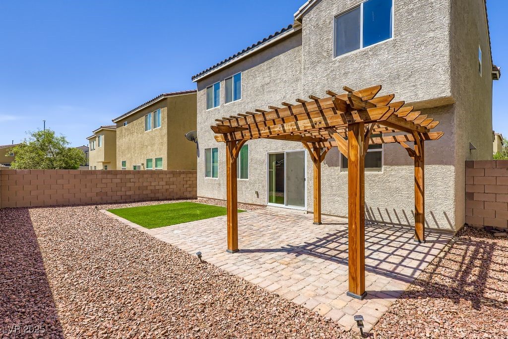 5712 Wishing Coin Court North Las Vegas, NV 89031 - Photo 23 of 24 Back of property with a pergola, a patio, a fenced backyard, and stucco siding
