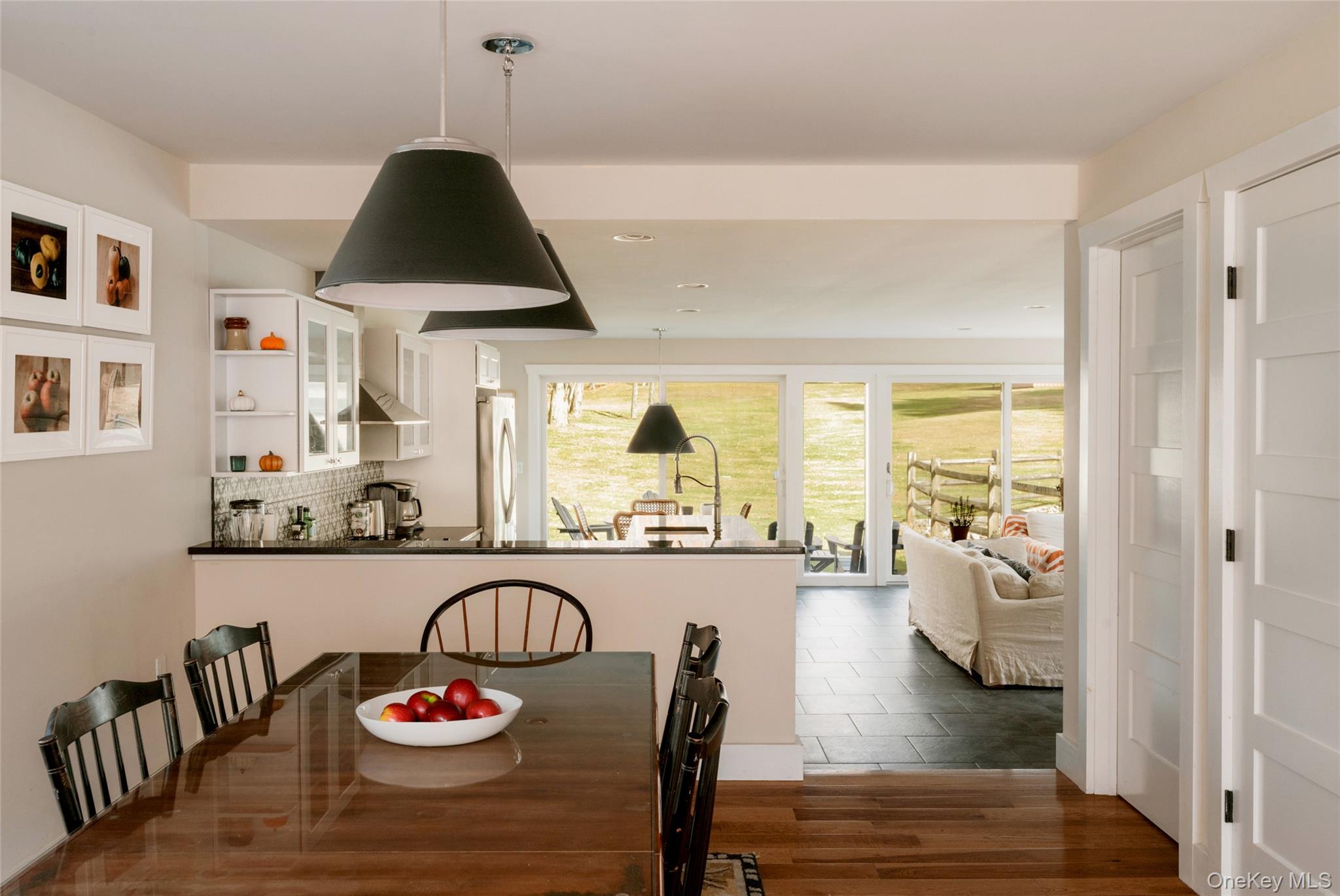 7775 State Rte 55 Neversink, NY 12765 - Photo 10 of 46 a view of a dining room and livingroom with furniture wooden floor a rug a potted plant and a chandelier