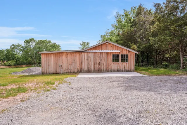 a view of a house with backyard and trees