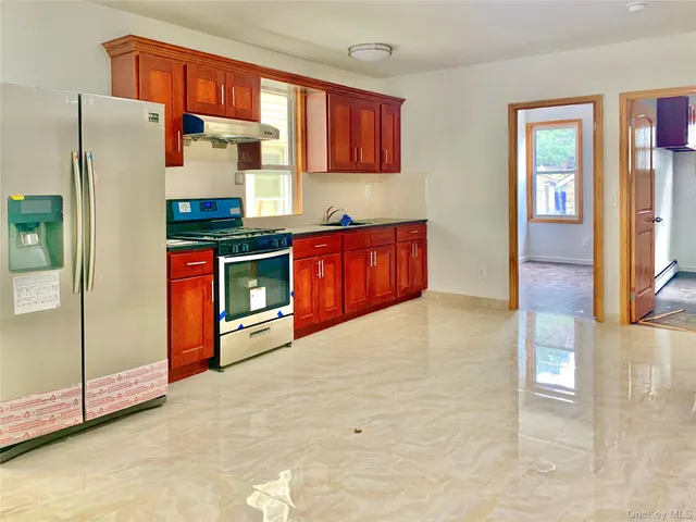 a kitchen with stainless steel appliances granite countertop a refrigerator and a sink