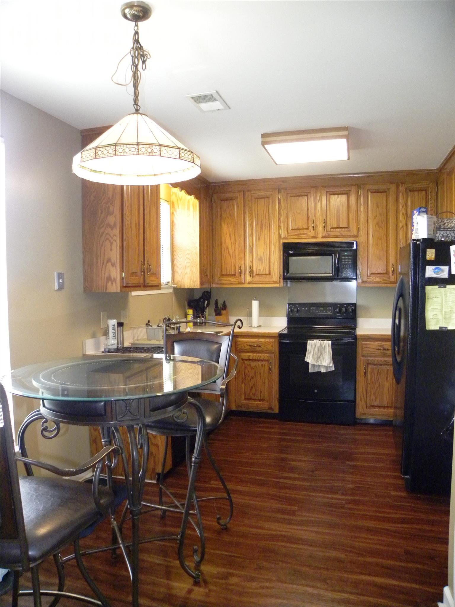 745 General George Patton Road Nashville, TN 37221 - Photo 3 of 12 a kitchen with stainless steel appliances granite countertop a stove top oven a sink dishwasher a dining table and chairs with wooden floor