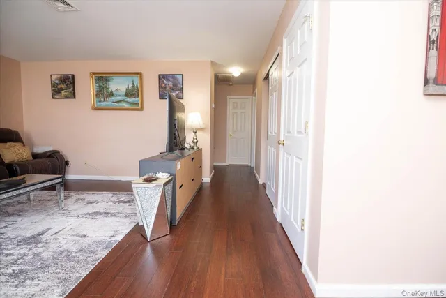 a view of a hallway with furniture and wooden floor