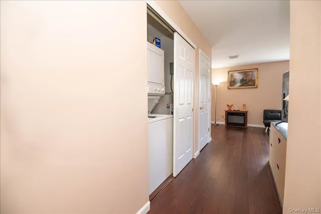 a view of a hallway with wooden floor and closet