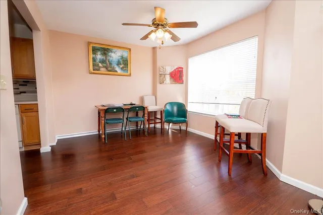 a dining room with wooden floor a chandelier a glass table and chairs