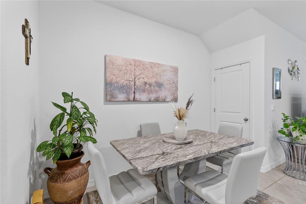 16632 Grotto Steam Place Wimauma, FL 33598 - Photo 11 of 42 a view of a dining room with furniture and wooden floor