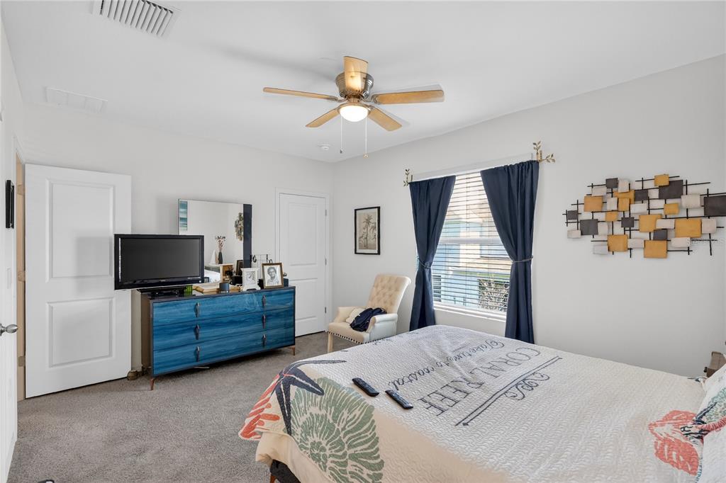 16632 Grotto Steam Place Wimauma, FL 33598 - Photo 13 of 42 a bedroom with a bed television and a window