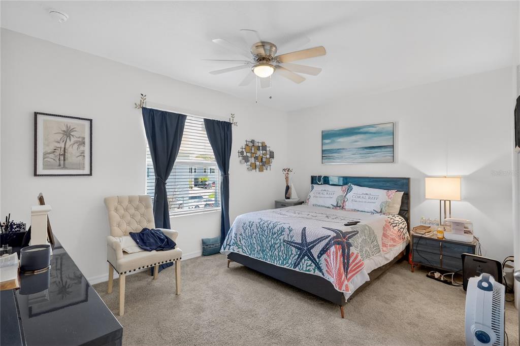 16632 Grotto Steam Place Wimauma, FL 33598 - Photo 14 of 42 a bedroom with a bed a couch and a chandelier