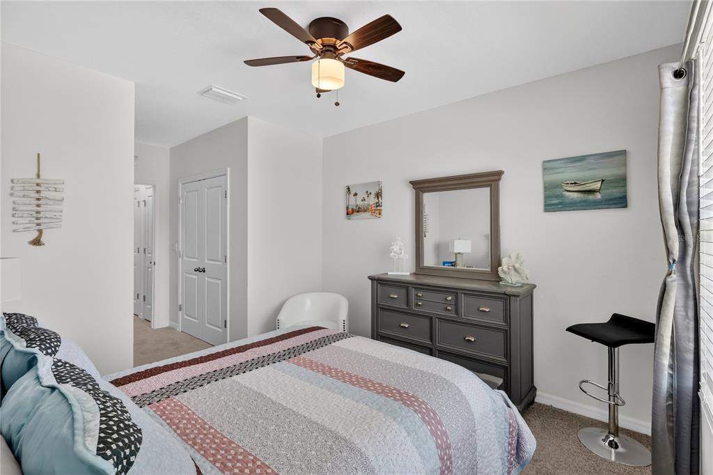 16632 Grotto Steam Place Wimauma, FL 33598 - Photo 18 of 42 a bedroom with a bed and a chandelier