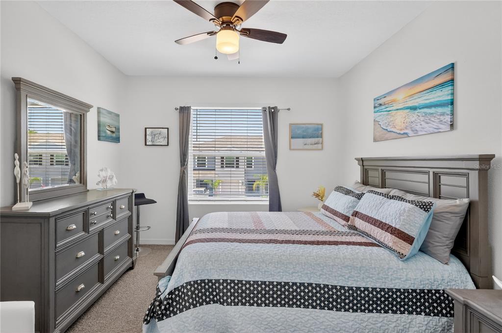 16632 Grotto Steam Place Wimauma, FL 33598 - Photo 19 of 42 a bedroom with a bed and a chandelier