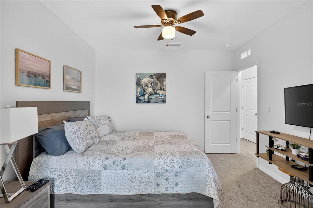 16632 Grotto Steam Place Wimauma, FL 33598 - Photo 20 of 42 a bedroom with a bed and a flat screen tv