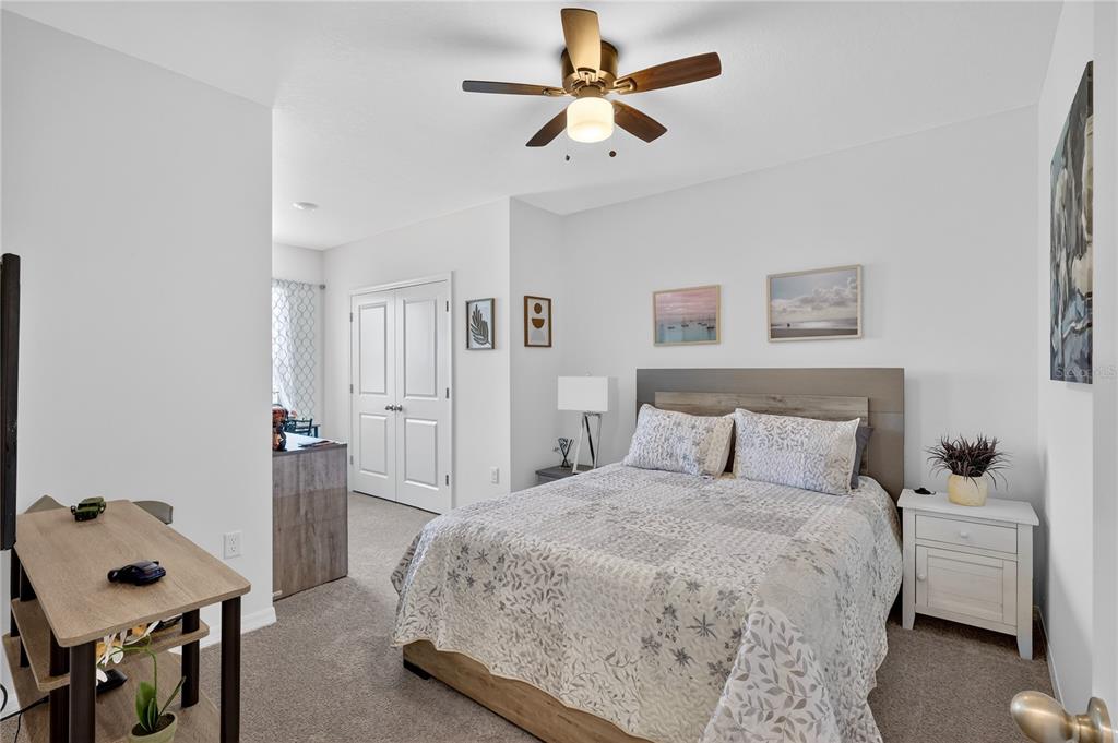 16632 Grotto Steam Place Wimauma, FL 33598 - Photo 22 of 42 a bedroom with a bed and a chandelier