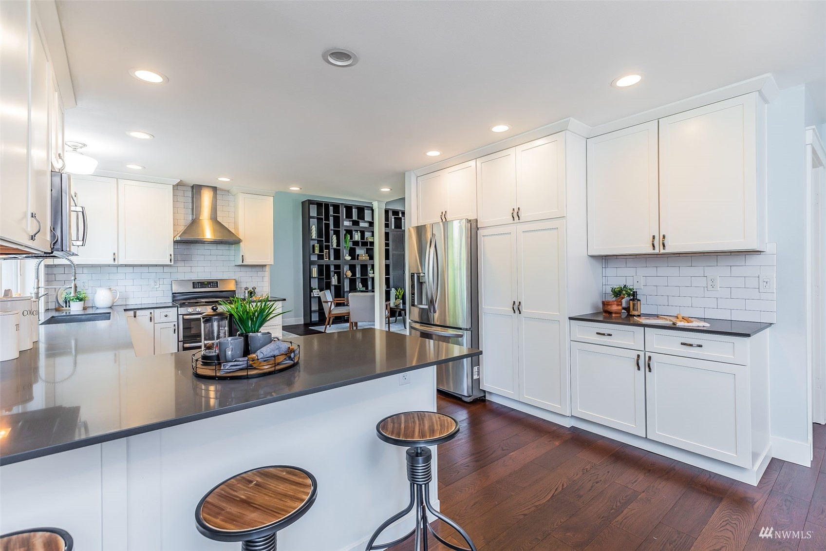 22110 14th Avenue West Bothell, WA 98021 - Photo 13 of 40 a kitchen with stainless steel appliances granite countertop a refrigerator a stove a sink and white cabinets with wooden floor