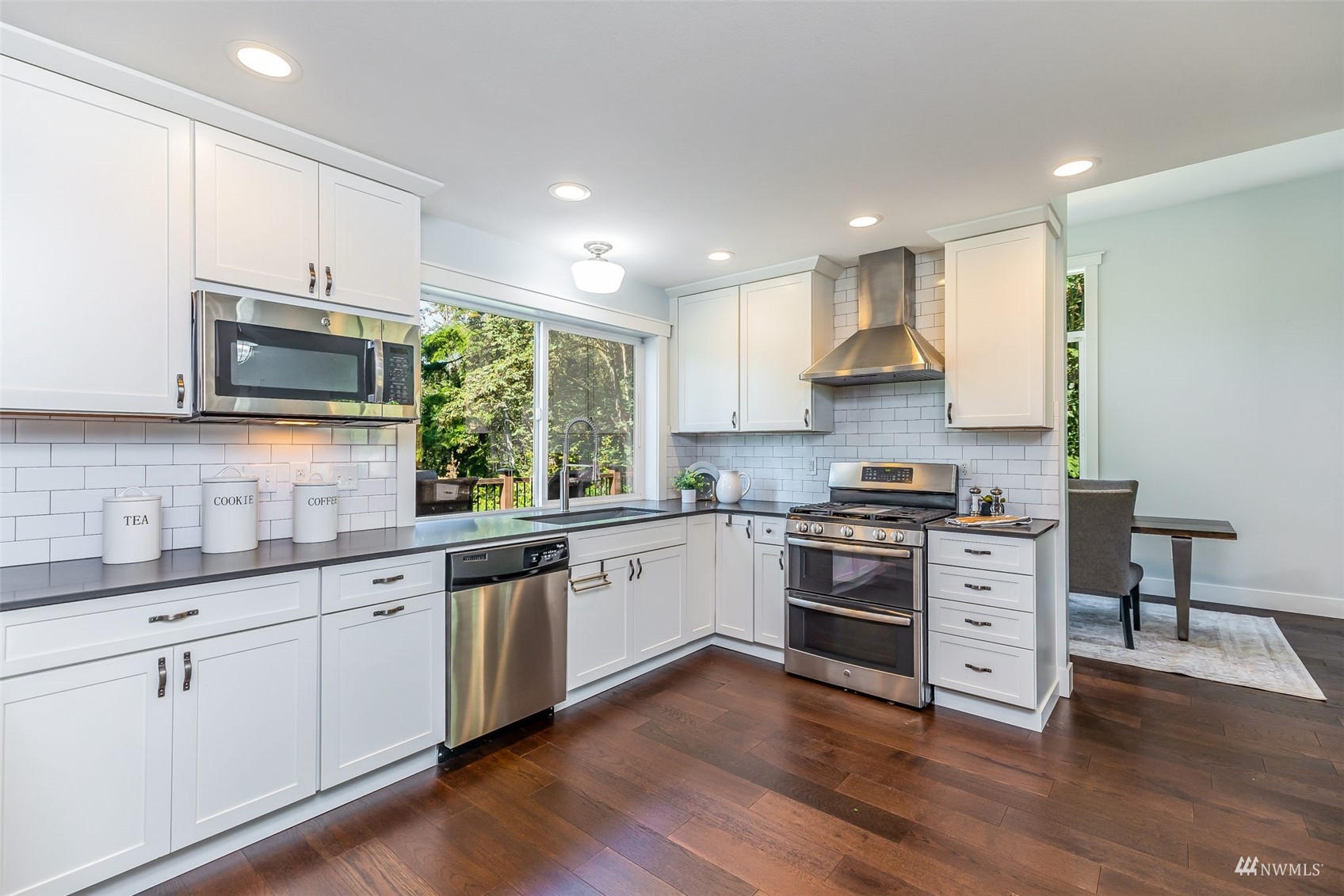 22110 14th Avenue West Bothell, WA 98021 - Photo 14 of 40 a kitchen with stainless steel appliances white cabinets a sink and wooden floor