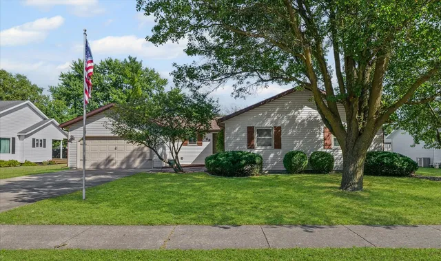 a front view of a house with a garden and trees