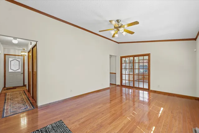 a view of an empty room with a window and wooden floor