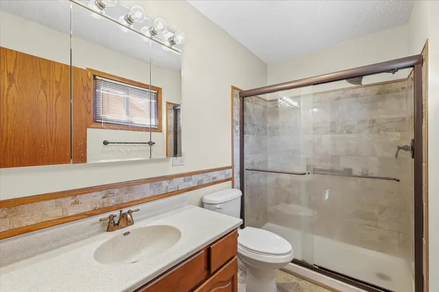 an empty room with windows and ceiling fan