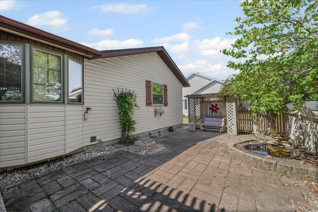 a view of a wooden house with a big yard and large trees
