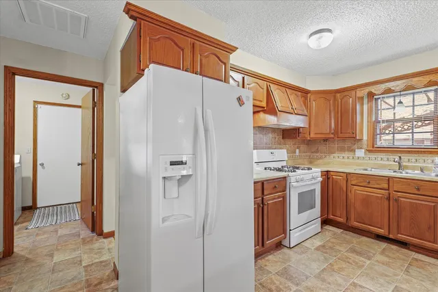 a kitchen with stainless steel appliances granite countertop a refrigerator and a sink
