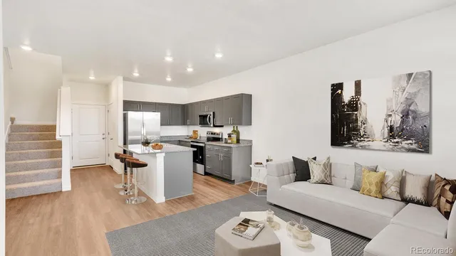 a living room with furniture and kitchen view