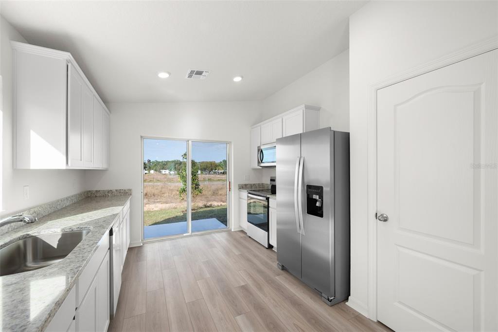 13328 Tula Loop Astatula, FL 34705 - Photo 3 of 18 a kitchen with a refrigerator and a sink