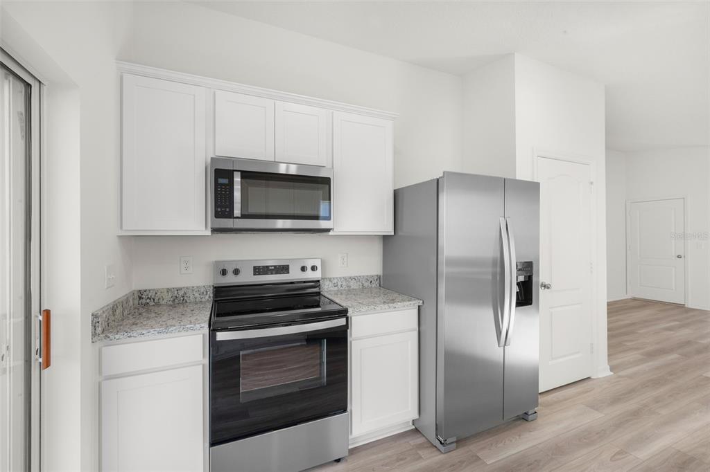 13328 Tula Loop Astatula, FL 34705 - Photo 6 of 18 a kitchen with a refrigerator stove and microwave