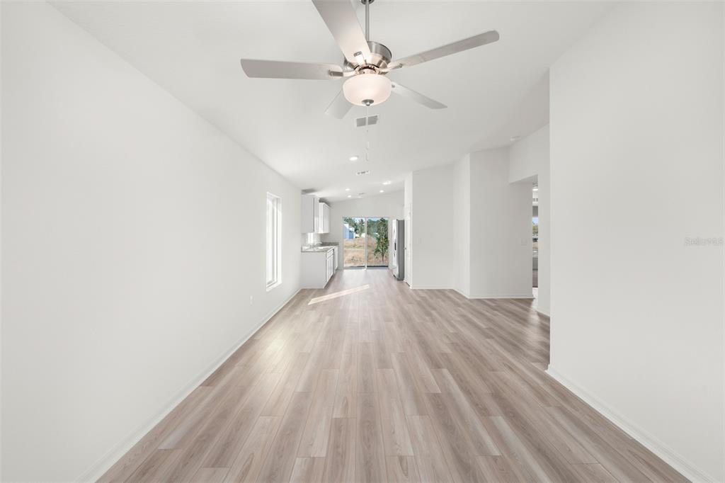 13328 Tula Loop Astatula, FL 34705 - Photo 8 of 18 a view of a room with wooden floor and a ceiling fan