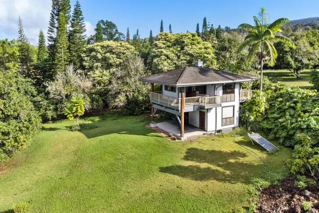 a view of a house with a yard and sitting area