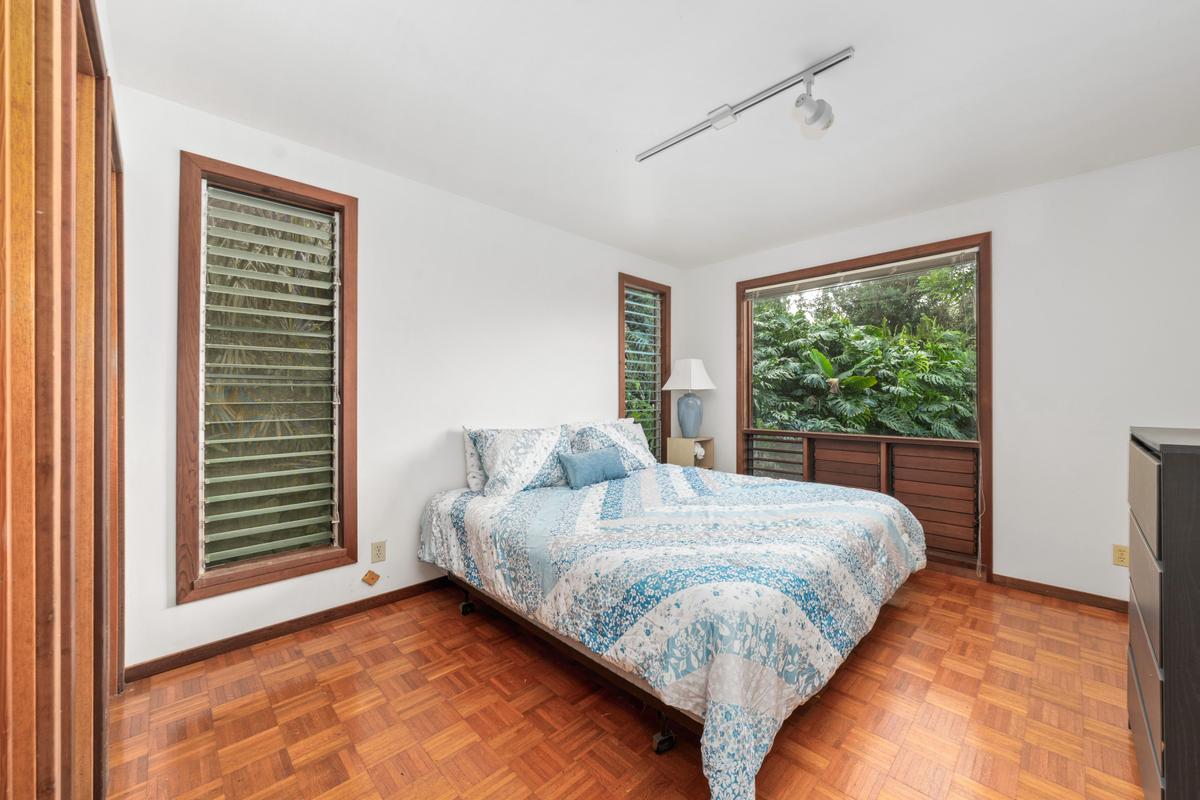 88-2497 Milolii Road Captain Cook, HI 96704 - Photo 14 of 30 a bed sitting in a bedroom next to a window