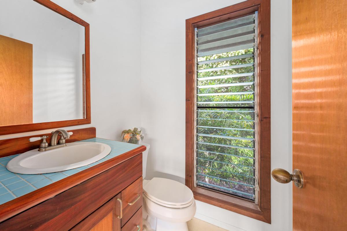 88-2497 Milolii Road Captain Cook, HI 96704 - Photo 15 of 30 a bathroom with a sink a toilet and a mirror