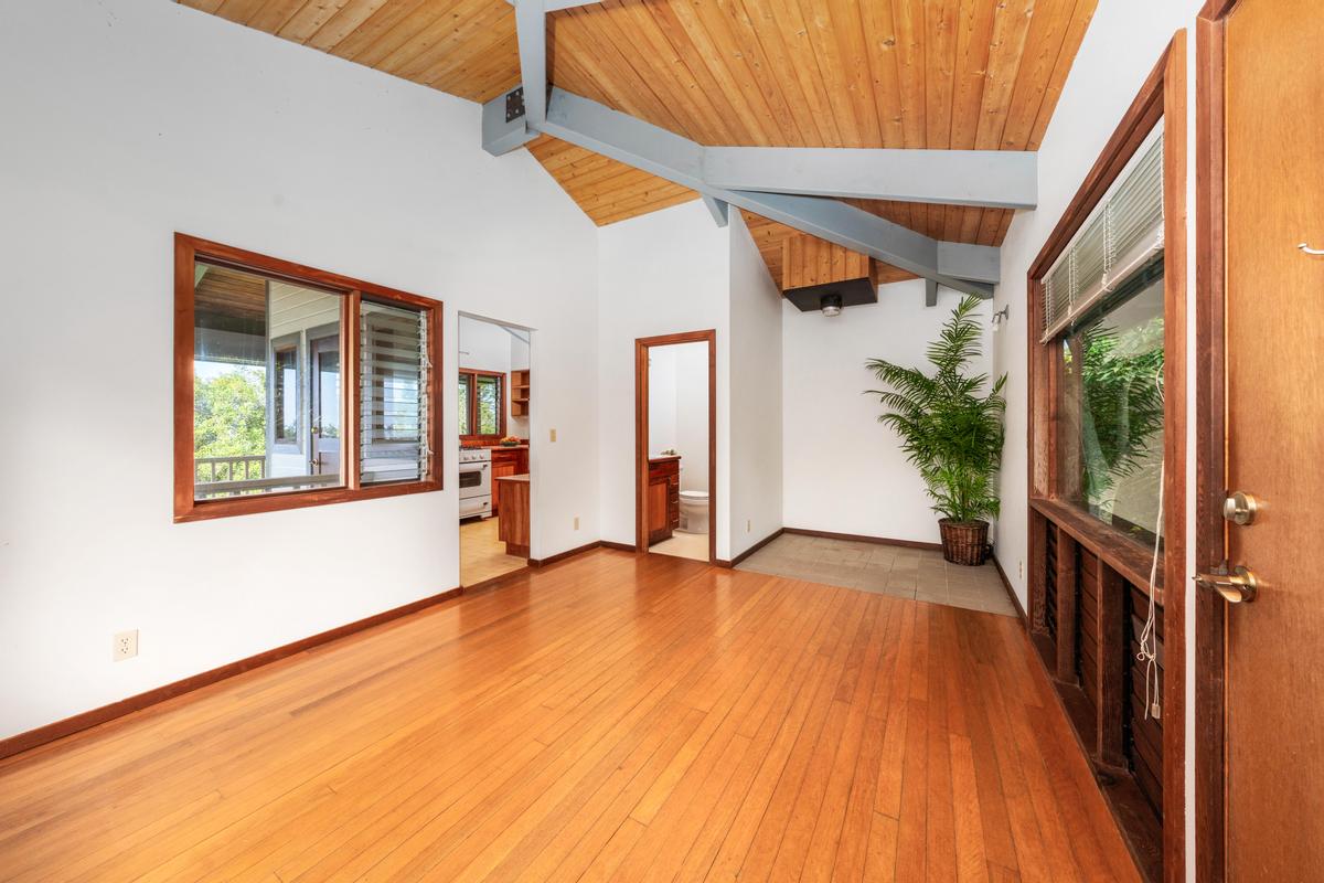 88-2497 Milolii Road Captain Cook, HI 96704 - Photo 5 of 30 a view of an empty room with a window and wooden floor
