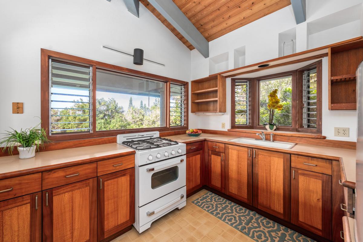 88-2497 Milolii Road Captain Cook, HI 96704 - Photo 9 of 30 a kitchen with stainless steel appliances granite countertop a stove a sink and a granite counter tops with wooden floors