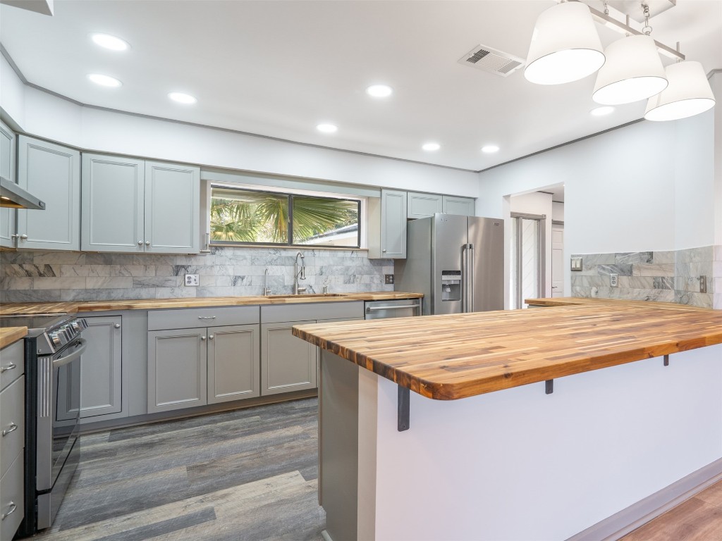 97578 Pirates Point Road Yulee, FL 32097 - Photo 20 of 64 a kitchen with stainless steel appliances granite countertop refrigerator sink and cabinets