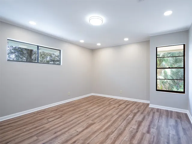 a view of a flower in a yard with large trees