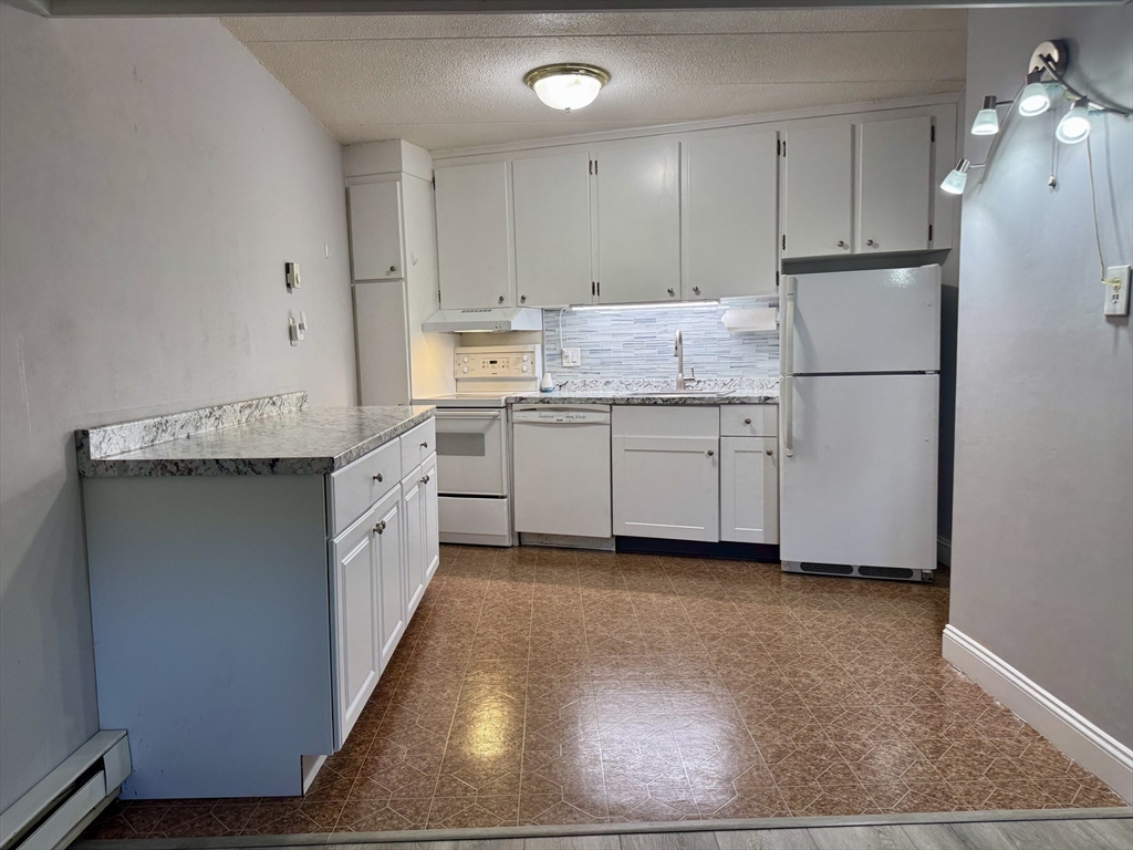 147 Turner Road, Unit 80 Holliston, MA 01746 - Photo 4 of 22 a kitchen with granite countertop a sink cabinets stainless steel appliances and a window