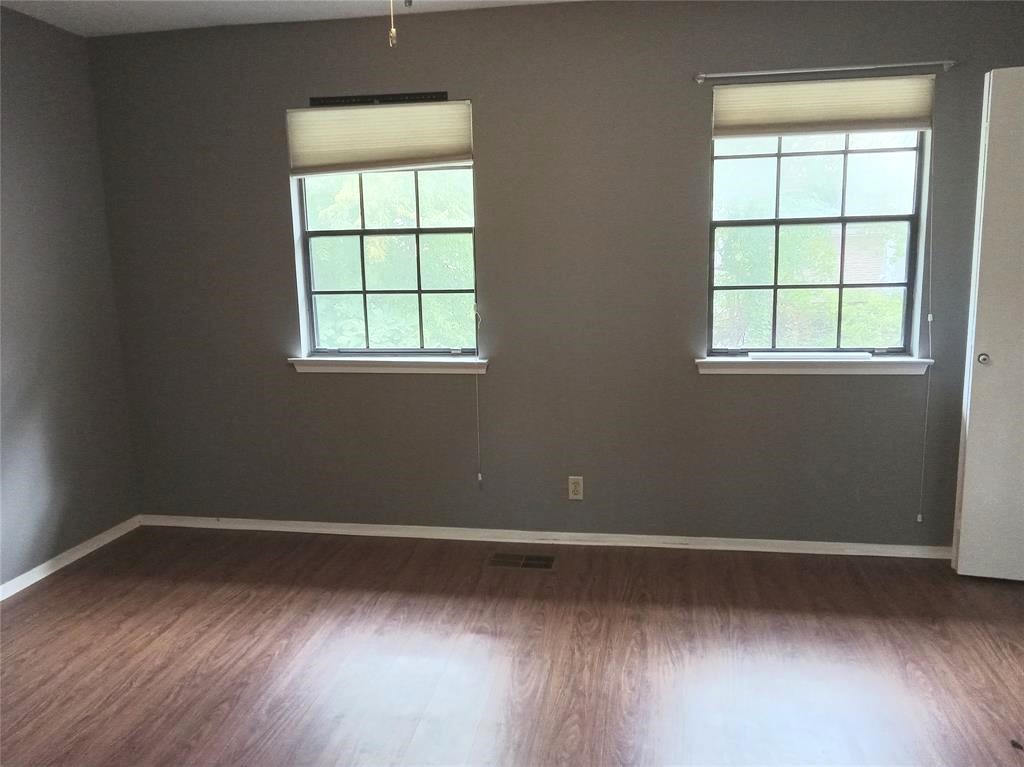 910 East Meadowmere Lane Austin, TX 78758 - Photo 17 of 27 an empty room with wooden floor and windows