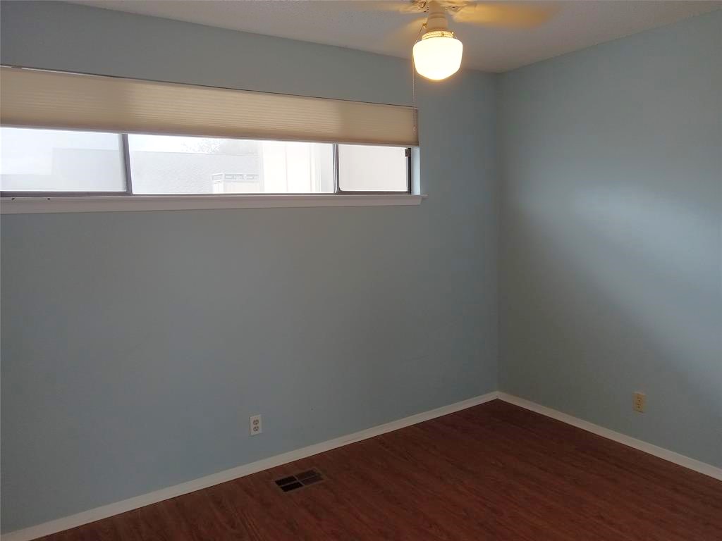910 East Meadowmere Lane Austin, TX 78758 - Photo 19 of 27 a view of an empty room with wooden floor and a window