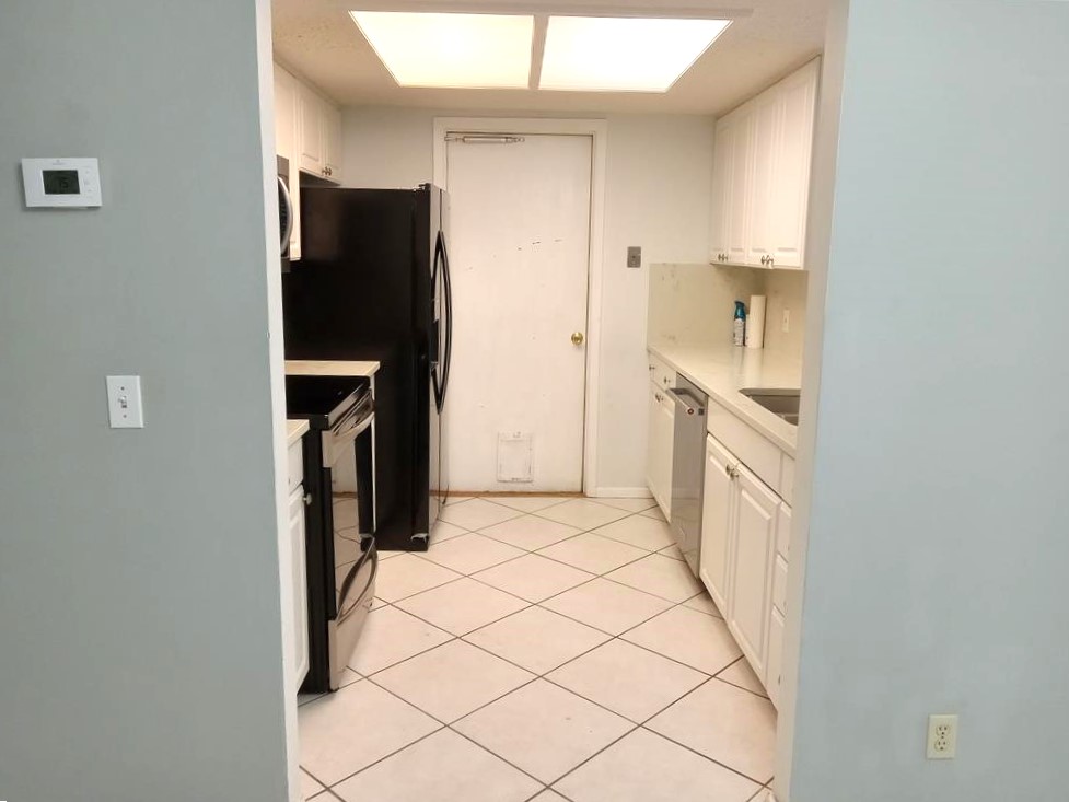 910 East Meadowmere Lane Austin, TX 78758 - Photo 5 of 27 a kitchen with a refrigerator and cabinets