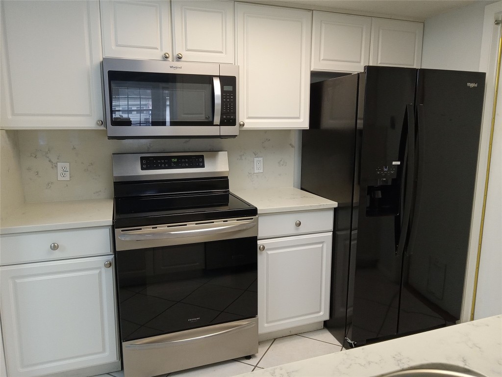 910 East Meadowmere Lane Austin, TX 78758 - Photo 6 of 27 a kitchen with a refrigerator stove and cabinets