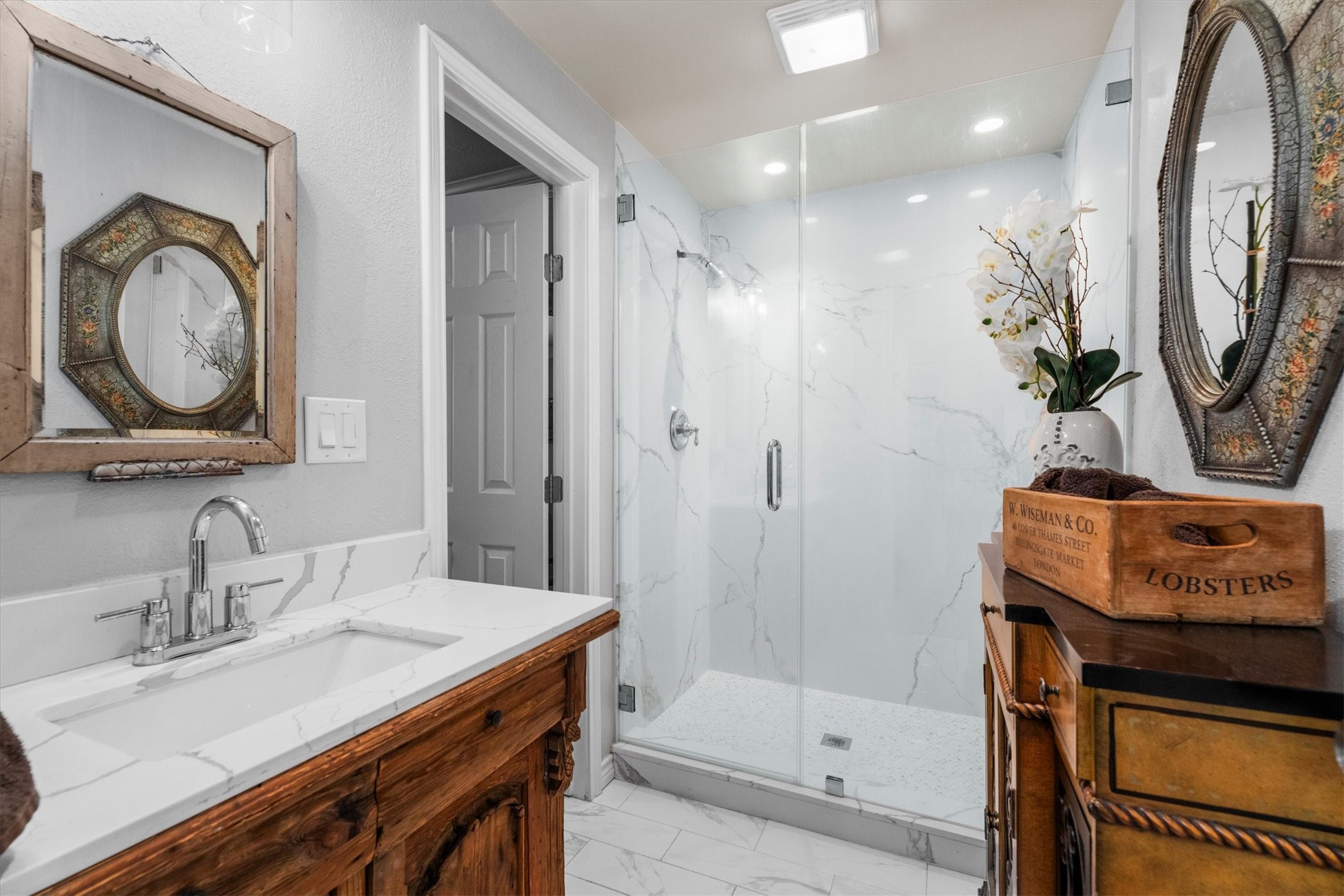 15902 Guinstead Drive Spring, TX 77379 - Photo 17 of 42 En-suite bath off of the office/bedroom which features a sleek, modern design with a glass-enclosed shower and marble-patterned walls.